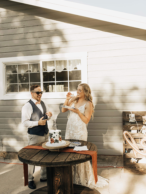 Bride and Groom eating Cake at their outdoor wedding
